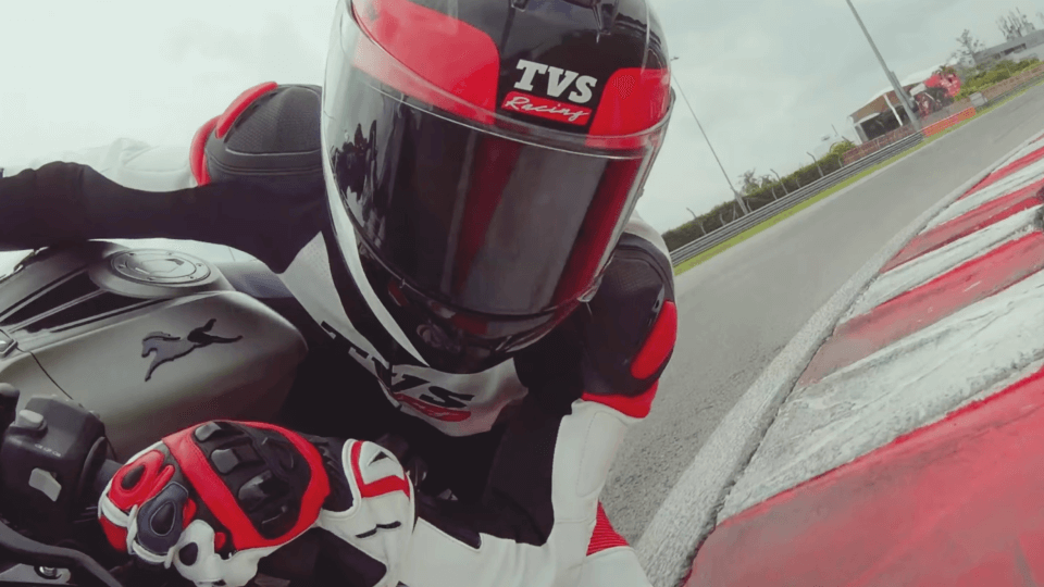 Motorcycle racer leaning into a sharp track corner.