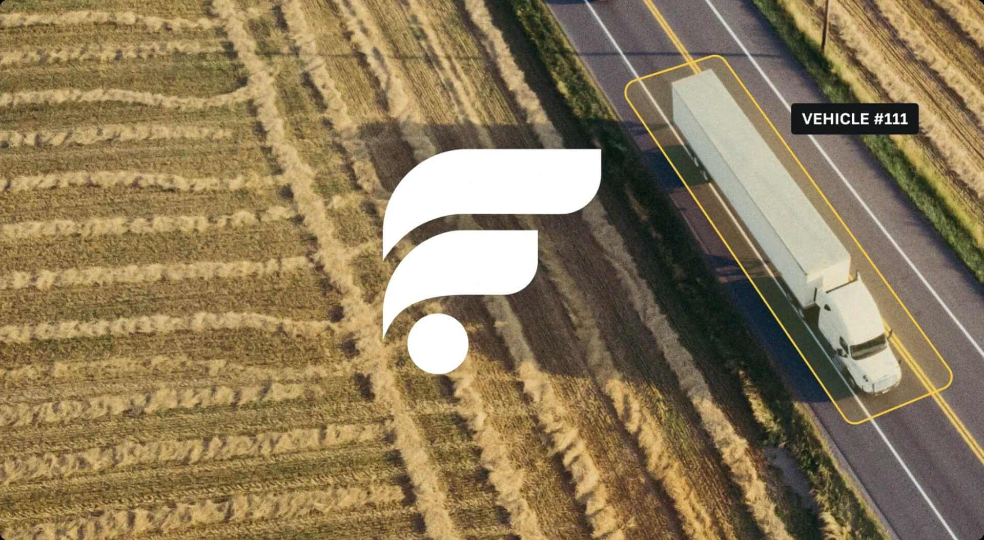  Aerial view of harvested fields beside a highway with a semi-truck