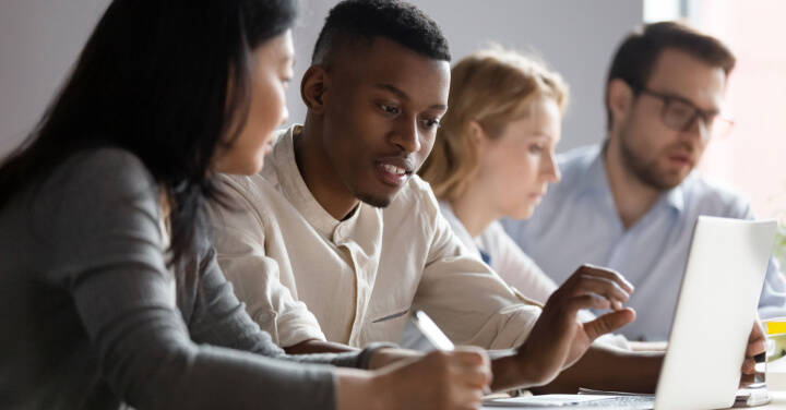 Diverse team collaborating on a laptop.
