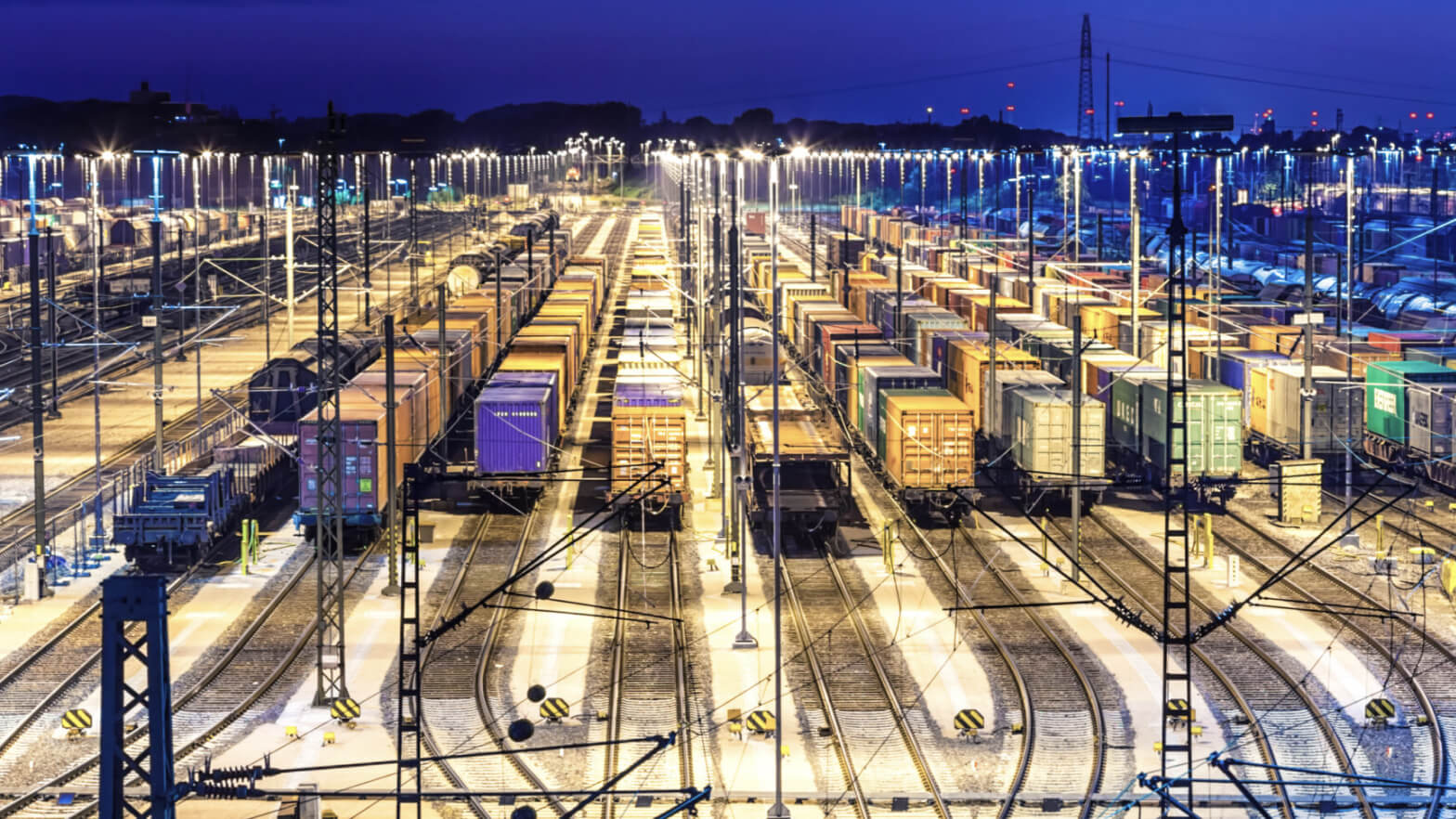 Illuminated freight train yard at night.
