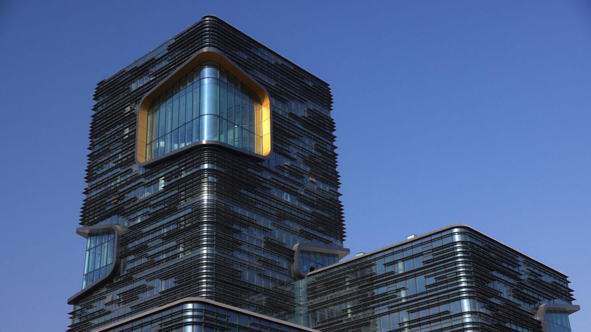 Modern building with golden-framed curved window.