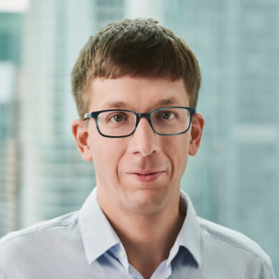 Headshot of a smiling man with glasses.