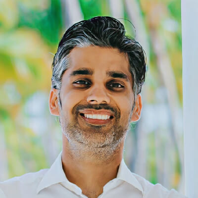 Smiling man with salt and pepper hair and beard.
