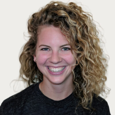 Smiling woman with curly blonde hair.
