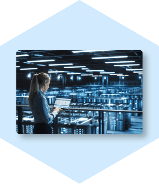 Woman monitoring data center with laptop.