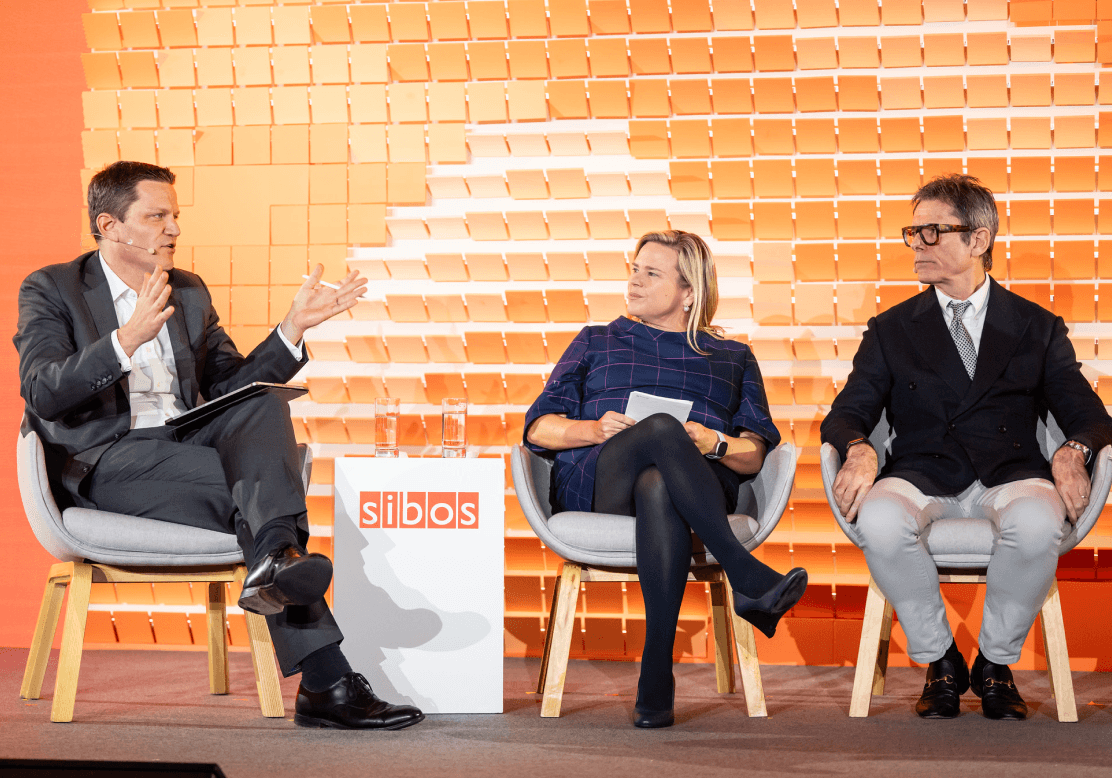 Three panelists on stage at a Sibos conference.