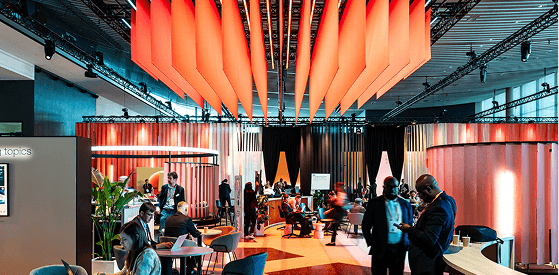 Conference hall with people and orange decor.