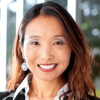 Smiling Asian woman in business attire.