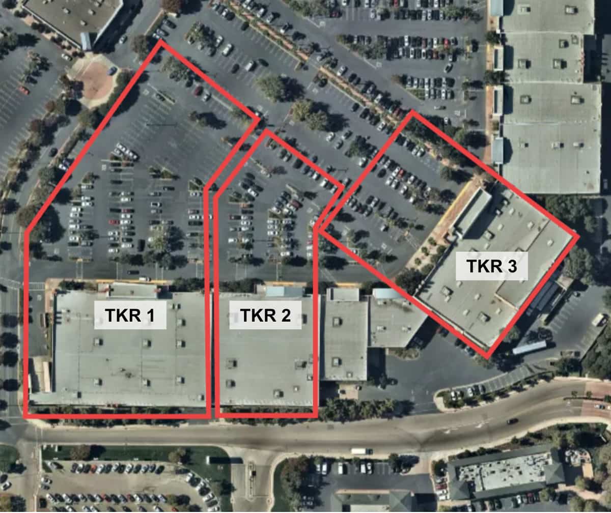 Figure 1: Aerial photograph of an open-air mall overlayed with geofence polygons (red) corresponding to the store location and parking lots of various companies of interest. Ticker symbols (text boxes) are representative of metadata associated with geofence polygons.