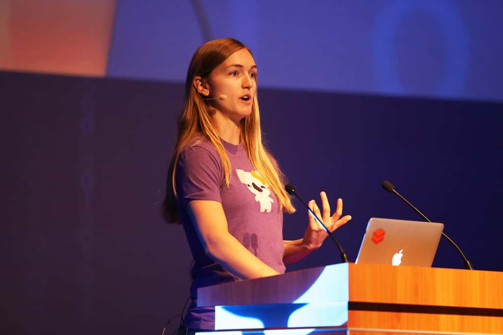 Brooke Wenig speaks behind a podium onstage at Spark Summit Europe 2019 in Amsterdam.