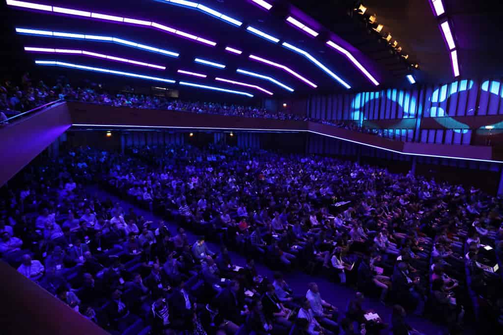 A view of the convention center theater from the balcony above, with attendees from Spark + AI Summit Europe in nearly every seat.